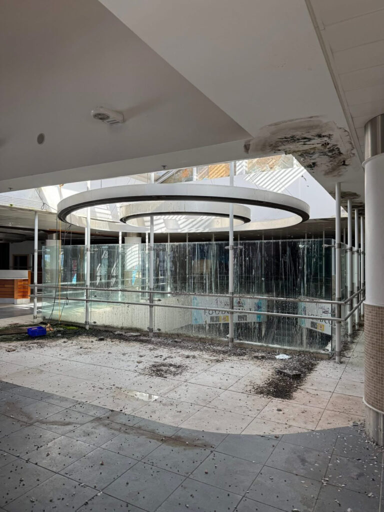 An urban explorer has revealed the eerie inside of a crumbling abandoned shopping mall in Bangor, Northern Ireland, left to rot with moss-covered floors, shattered windows and a collapsing roof.