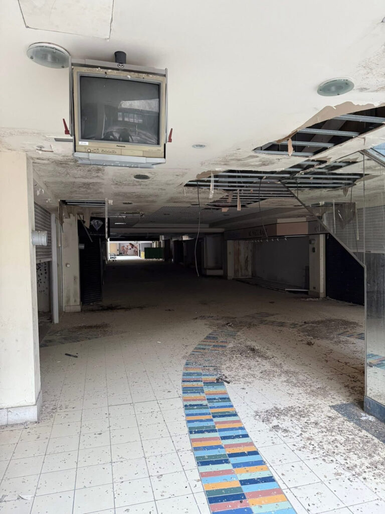An urban explorer has revealed the eerie inside of a crumbling abandoned shopping mall in Bangor, Northern Ireland, left to rot with moss-covered floors, shattered windows and a collapsing roof.