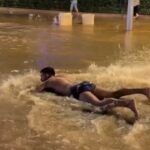 A TikToker went viral in Ibiza after belly flopping into a flooded street and pretending to swim as heavy rain left roads waterlogged and crews battled to clear the damage.