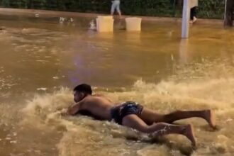 A TikToker went viral in Ibiza after belly flopping into a flooded street and pretending to swim as heavy rain left roads waterlogged and crews battled to clear the damage.