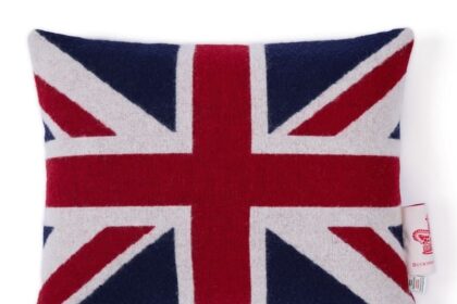 King Charles is selling a £95 merino wool Union Jack cushion, sparking debate over whether it’s a pricey royal indulgence or a cosy nod to British pride.