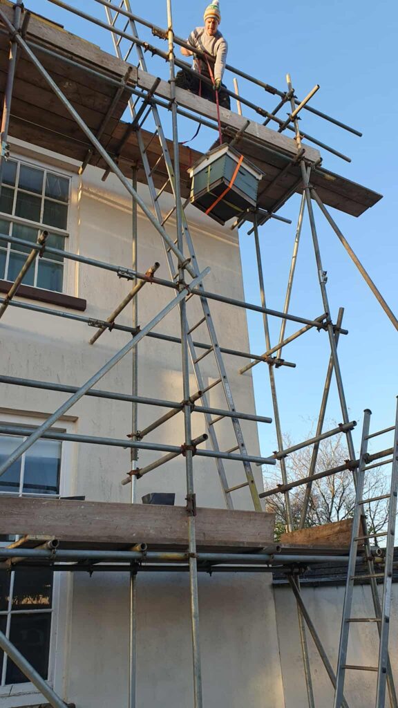 One of the roofers, with the rescued massive bee colony inside the box.
