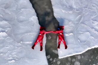 A new extreme winter trend called ice floating is going viral - thrill-seekers in red suits dive into freezing Arctic waters in Russia for the ultimate icy adventure.