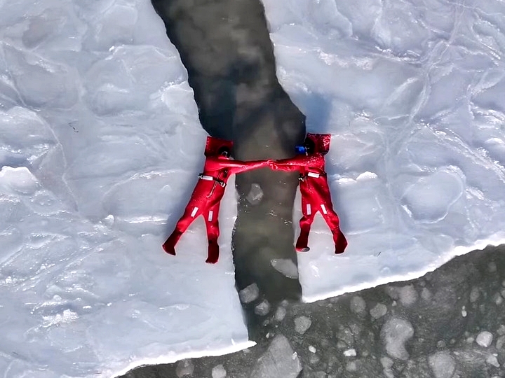 A new extreme winter trend called ice floating is going viral - thrill-seekers in red suits dive into freezing Arctic waters in Russia for the ultimate icy adventure.