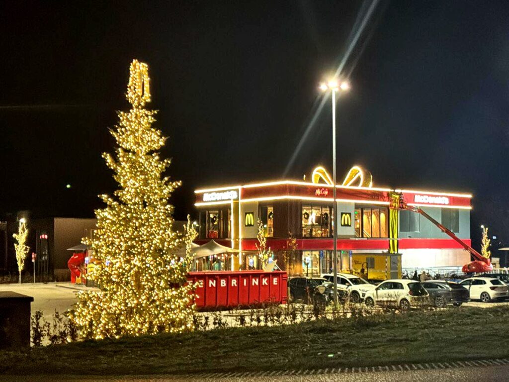 Dutch McDonald’s in Vriezenveen transforms into a giant Christmas present with a glowing bow offering festive giveaways sustainable design features and a celebratory opening for locals.