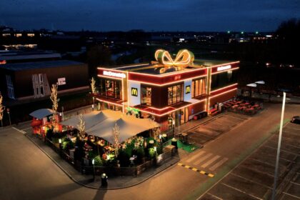 Dutch McDonald’s in Vriezenveen transforms into a giant Christmas present with a glowing bow offering festive giveaways sustainable design features and a celebratory opening for locals.