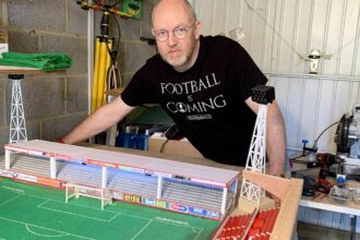 A football fan built a 6,000-seater Subbuteo replica of Cheltenham Town’s stadium in his garage, even selling his classic car to make space for the incredible lockdown project.