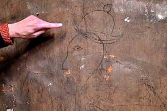 Graffiti discovered at Hampton Court Palace depicts the man in period dress, wearing a coat and headwear and holding an arrow, with 1626 carved beneath it.