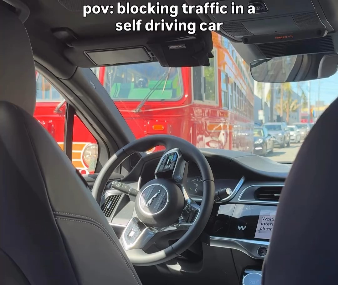 A woman was left mortified when a self-driving Waymo car froze in an intersection blocking a trolley - leaving passengers helpless as honking drivers watched the chaos unfold.