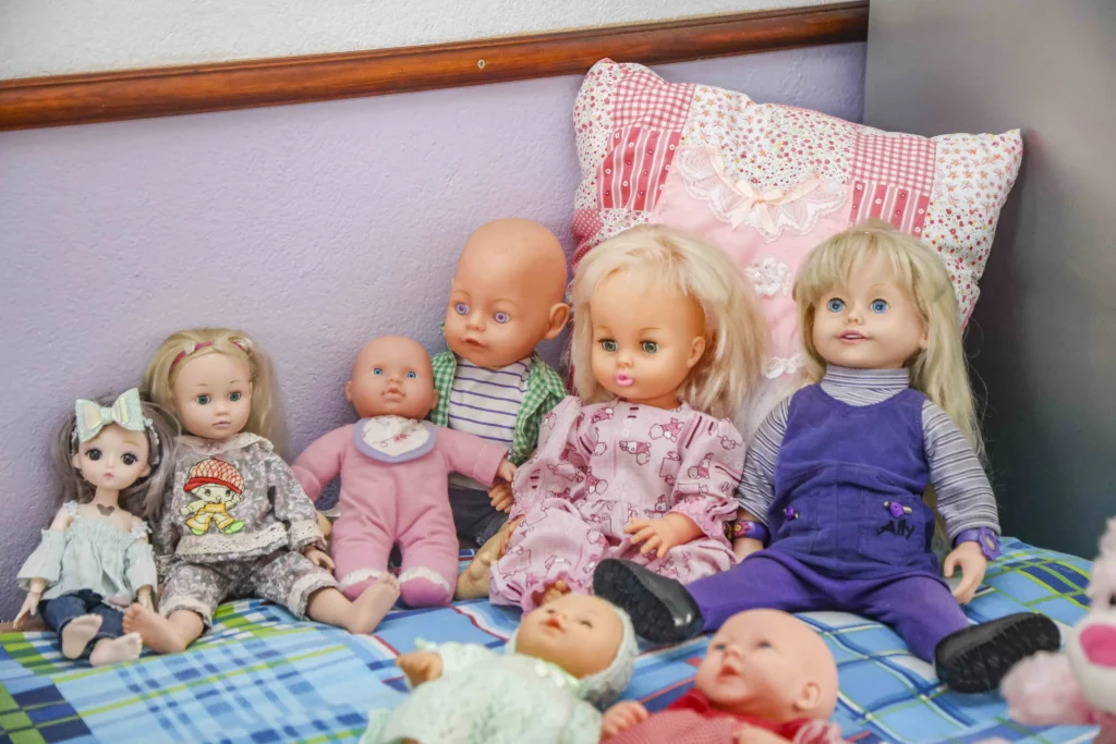 South African woman Marie Odendaal lives with 100 dolls and makes 400 outfits a week treating them as her babies as she talks to them proudly and supports her daughter through her doll clothing business.