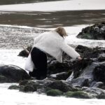 Christmas shopper soaked by rising tide in Newquay after shortcut across seaweed covered rocks goes wrong leaving her wet but safe as amused locals react to the festive mishap.