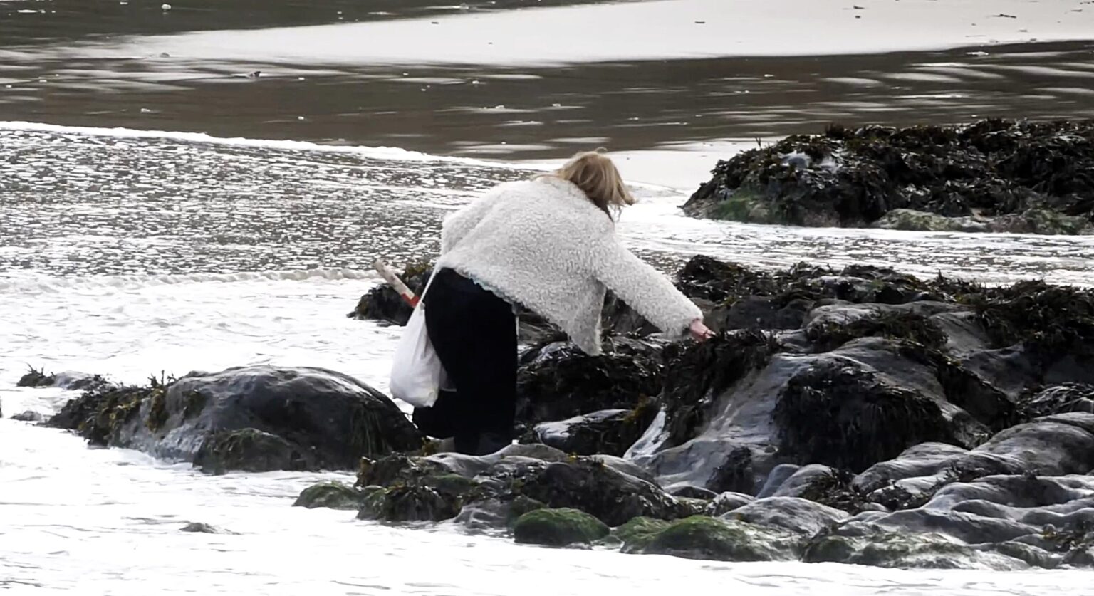 Christmas shopper soaked by rising tide in Newquay after shortcut across seaweed covered rocks goes wrong leaving her wet but safe as amused locals react to the festive mishap.