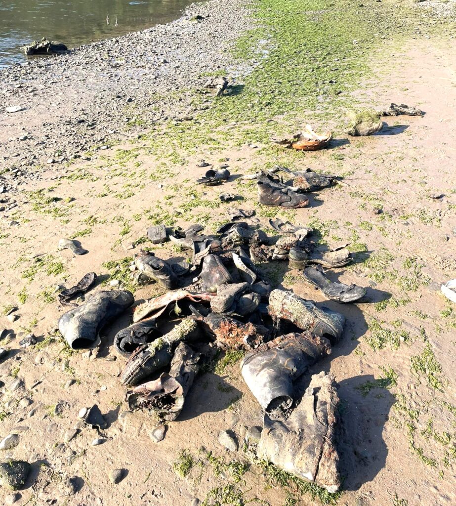 Hundreds of handmade leather shoes from a 150 year old shipwreck wash up on Welsh beach, baffling volunteers as rare footwear emerges from rock pools after erosion.