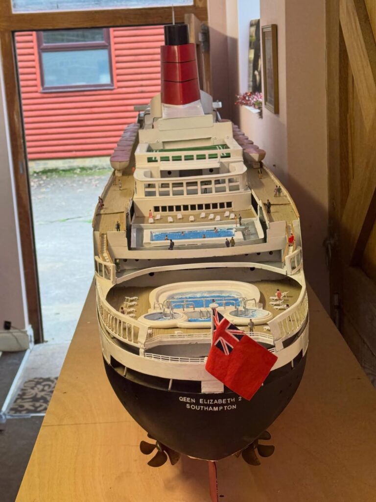 Retired craftsman builds stunning 13ft QE2 model over five months using original blueprints, complete with passengers, pool and lights, now on display in Kent.