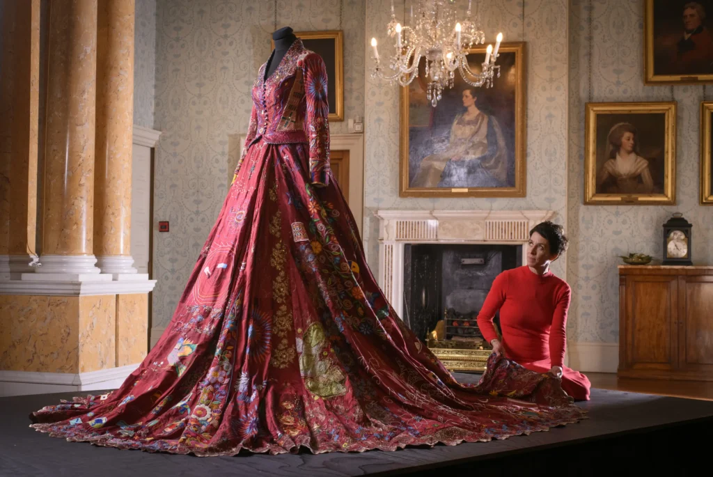 A world record-breaking dress created by 380 people across 51 countries over 14 years has gone on display, featuring 1.5 billion stitches and weighing 15lb with elaborate embroidered panels.