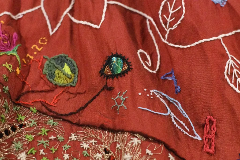 A world record-breaking dress created by 380 people across 51 countries over 14 years has gone on display, featuring 1.5 billion stitches and weighing 15lb with elaborate embroidered panels.