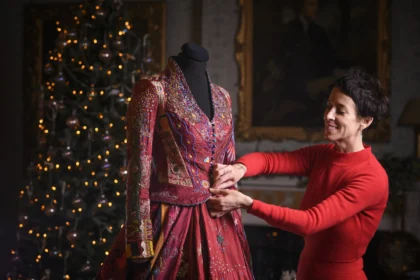 A world record-breaking dress created by 380 people across 51 countries over 14 years has gone on display, featuring 1.5 billion stitches and weighing 15lb with elaborate embroidered panels.