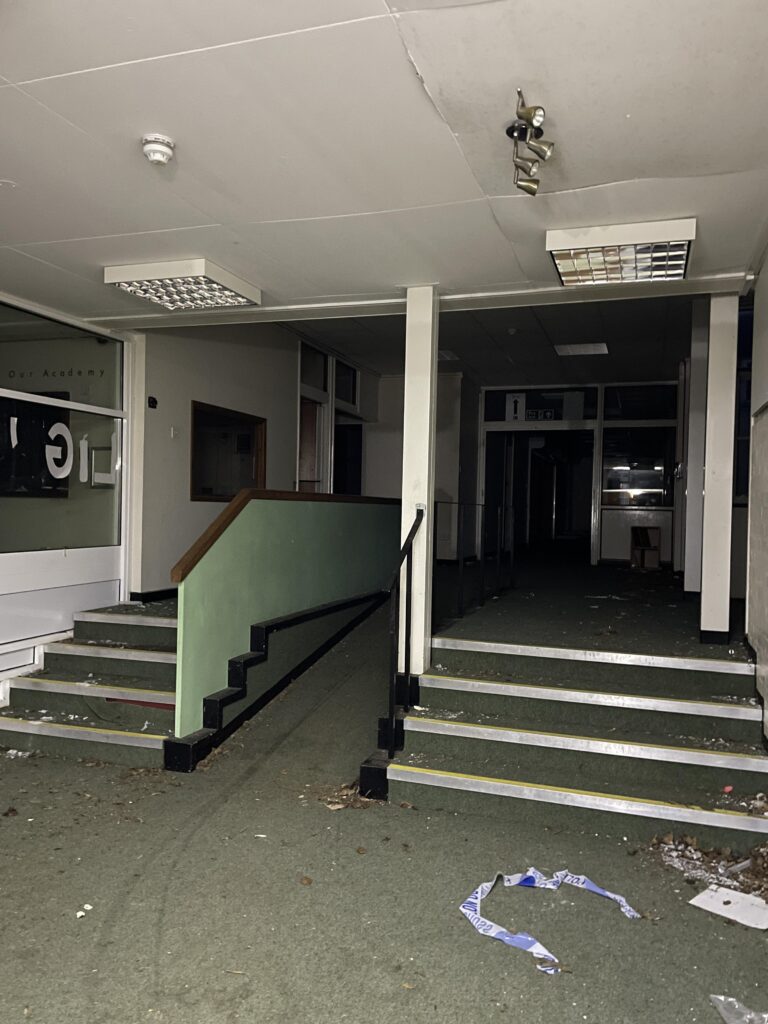 Urban explorer uncovers eerie abandoned primary school frozen in time since 2012, with ivy filled classrooms mouldy halls and grass growing indoors near Kent in darkness.