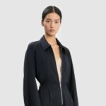 Victoria Beckham’s new £1,190 cargo jumpsuit sparks chatter for its mechanic style look as the designer reimagines workwear with wool blend fabric silver zips and utilitarian details.