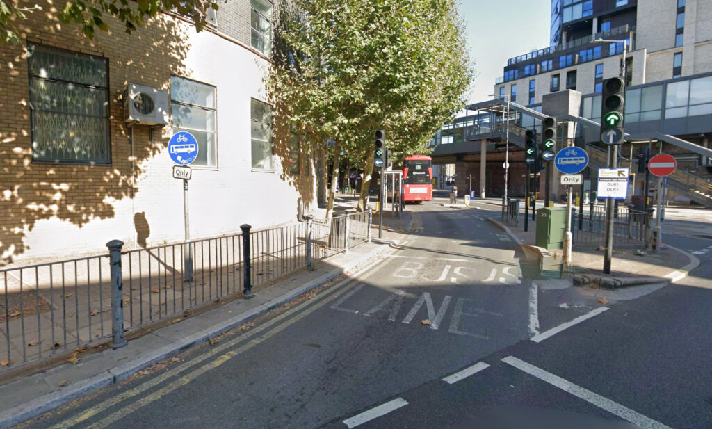 Double decker bus smashes into a bus lane sign in Docklands during rush hour leaving the front badly damaged as onlookers joke and a tow truck clears the road.