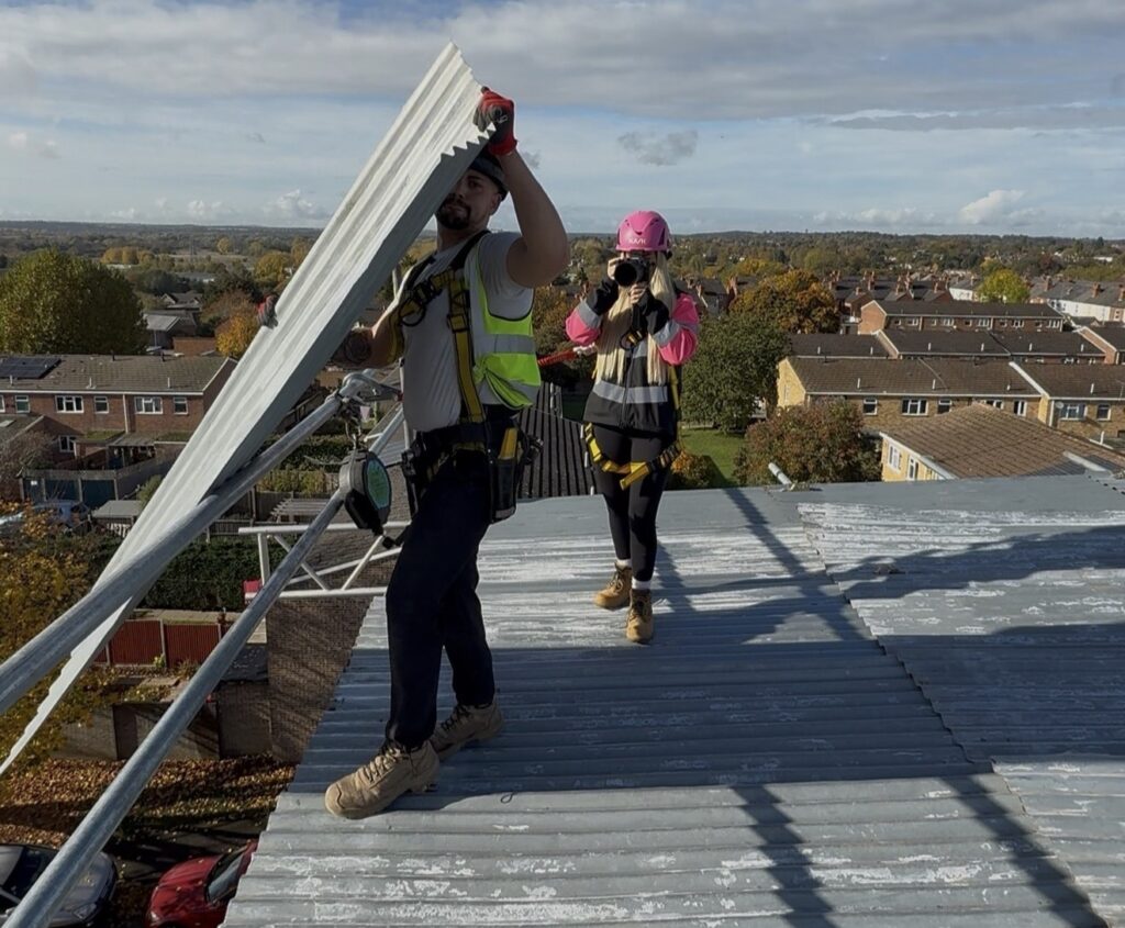 Pink hard hat videographer Abbey Moring defies critics filming scaffolding sites at height turning a mans world into viral marketing success for her boyfriends business .