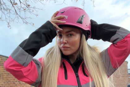 Pink hard hat videographer Abbey Moring defies critics filming scaffolding sites at height turning a mans world into viral marketing success for her boyfriends business .