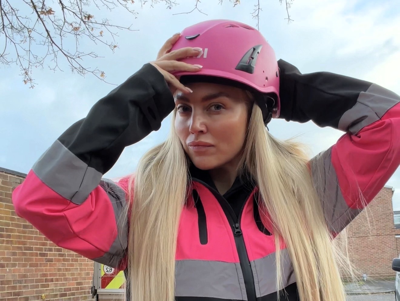 Pink hard hat videographer Abbey Moring defies critics filming scaffolding sites at height turning a mans world into viral marketing success for her boyfriends business .