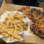 Leeds United charges £9 for burned pizza and chips at Elland Road. Fan shares disappointing 10-inch stone-baked pizza and pale fries from Man Utd match.