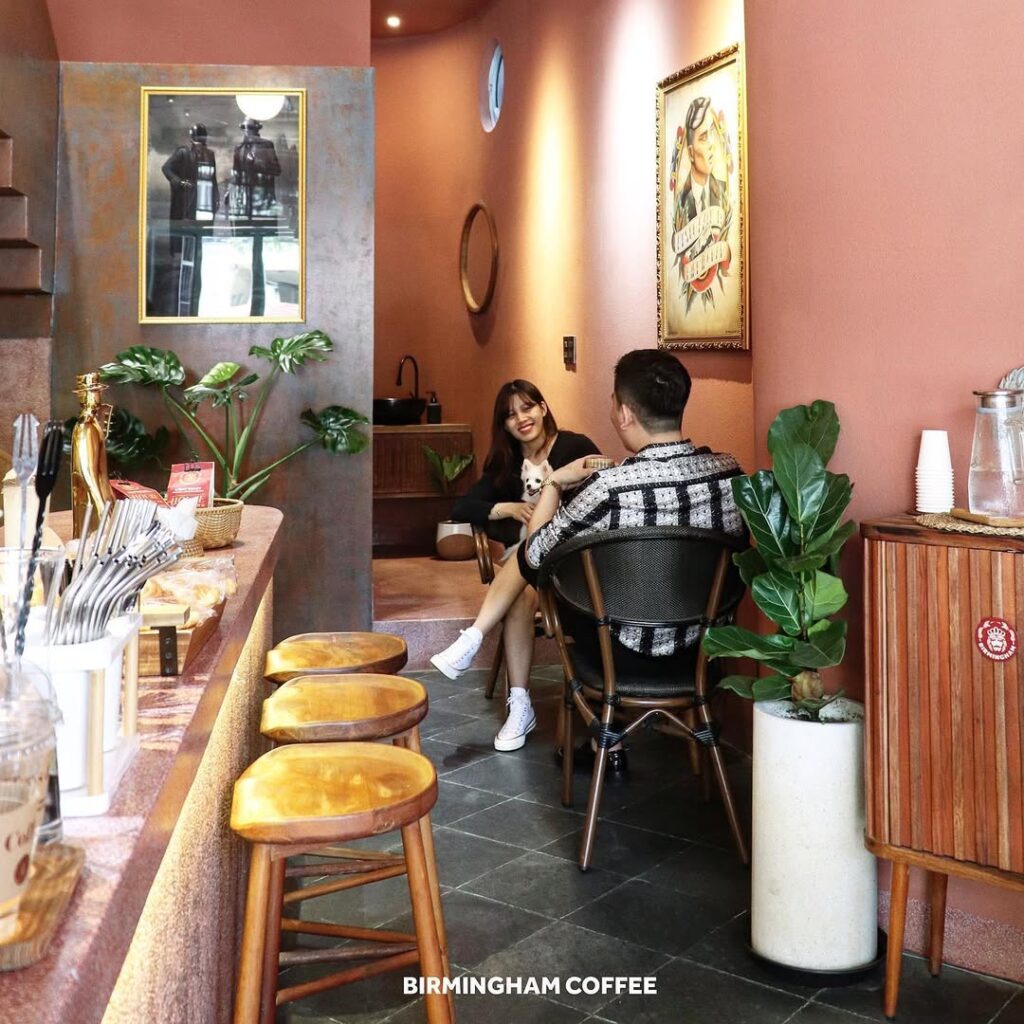 British backpackers discover Birmingham Coffee cafe in Nha Trang, Vietnam, 6,000 miles away, featuring Peaky Blinders art and Bull Ring pictures with cheap lattes.