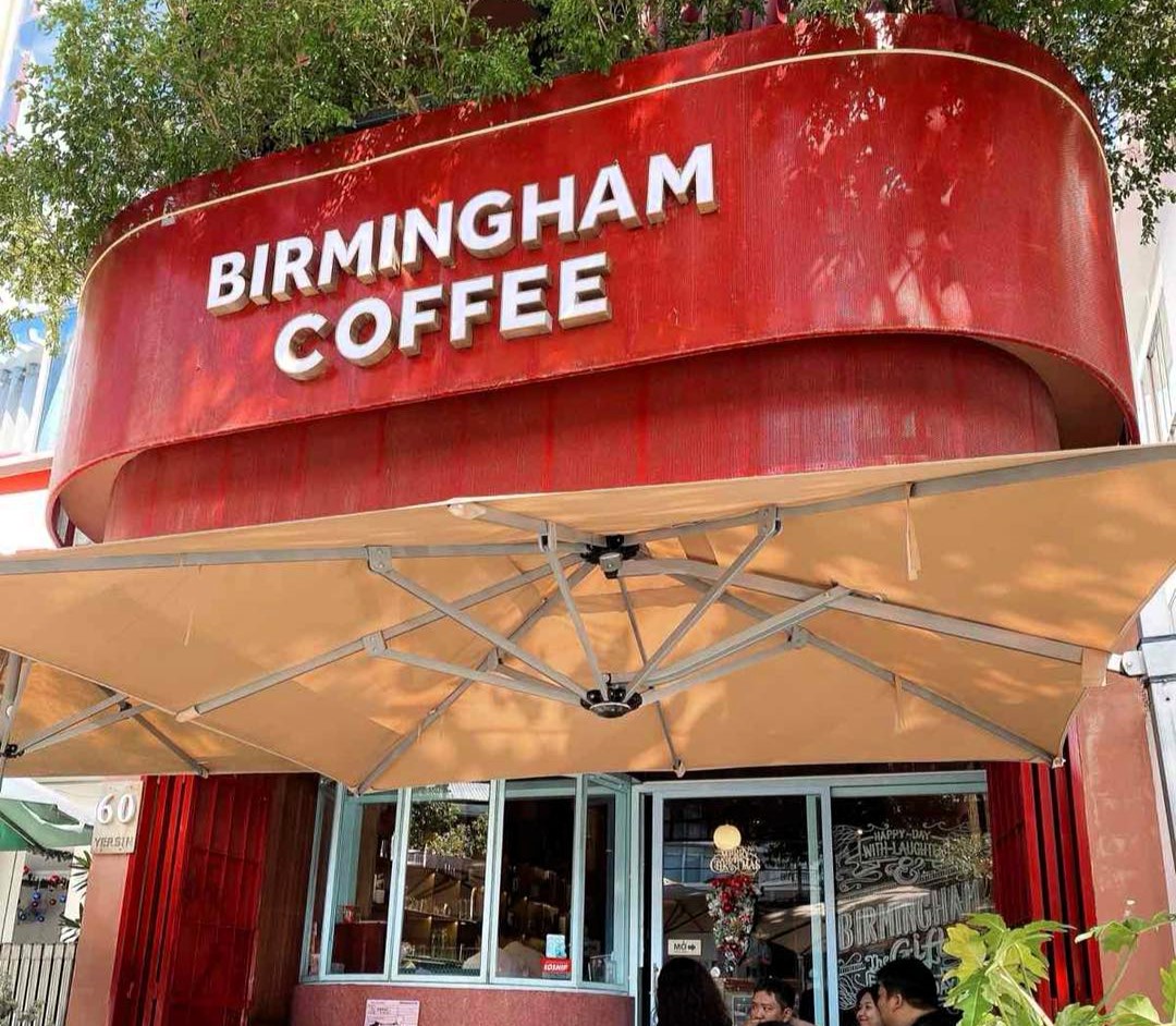 British backpackers discover Birmingham Coffee cafe in Nha Trang, Vietnam, 6,000 miles away, featuring Peaky Blinders art and Bull Ring pictures with cheap lattes.