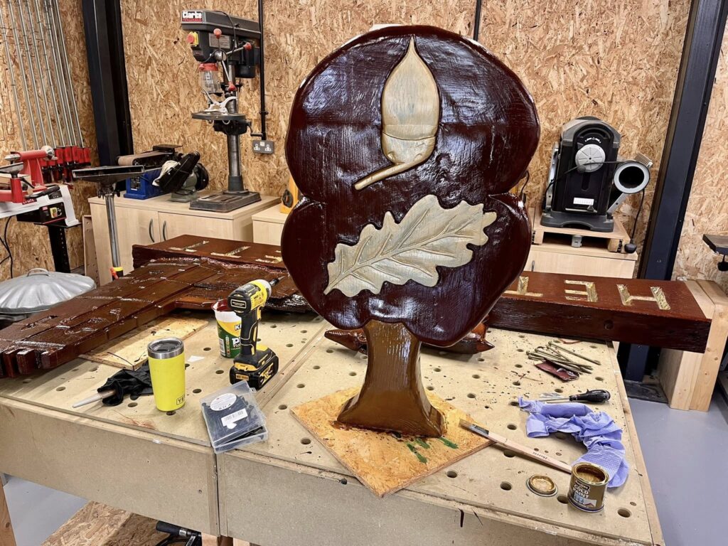 Lorry driver spends six weeks hand-restoring 50-year-old Hethersett village sign near Norwich. Self-taught Craig Jenkins saved the rotten oak carving for locals.