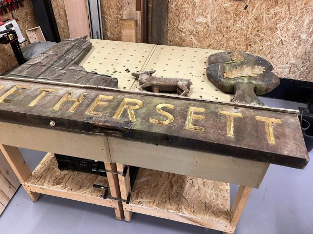 Lorry driver spends six weeks hand-restoring 50-year-old Hethersett village sign near Norwich. Self-taught Craig Jenkins saved the rotten oak carving for locals.