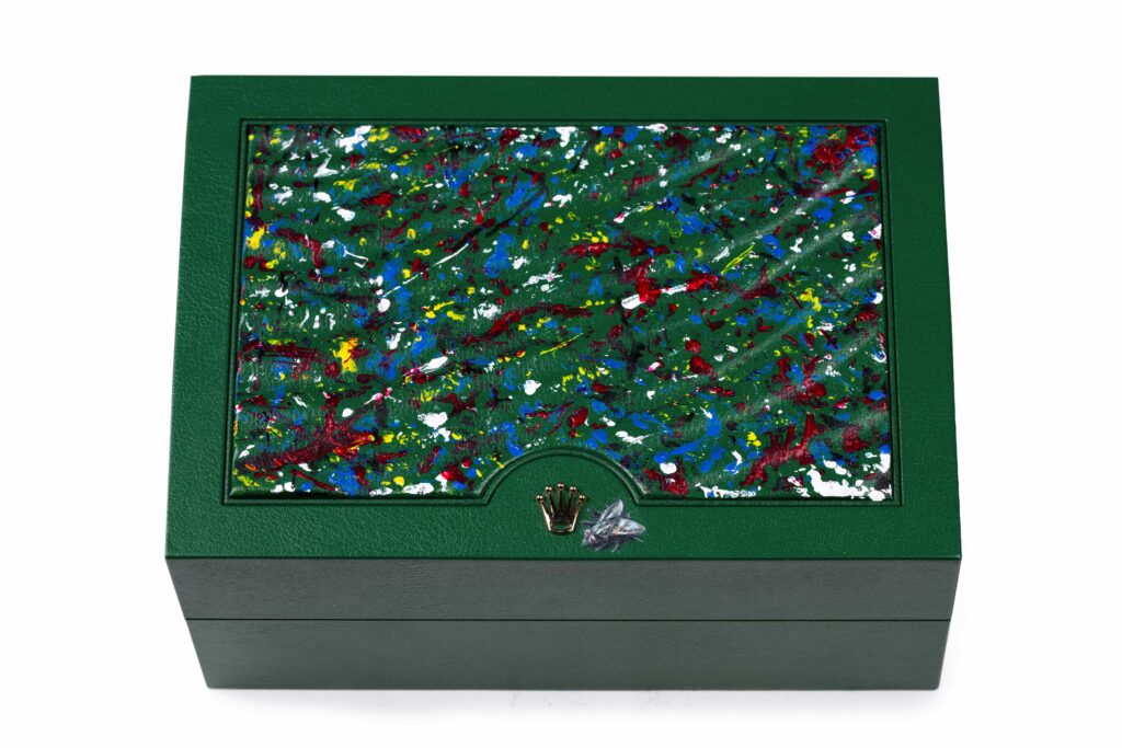 An artist turned a Rolex into abstract art by letting paint covered flies splatter the watch face, creating a one of a kind piece that stunned millions online.