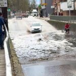 A fearless cyclist pedalled through knee deep floodwater on Heath Road in Twickenham, unfazed even as a passing car sent waves crashing over her under a bridge
