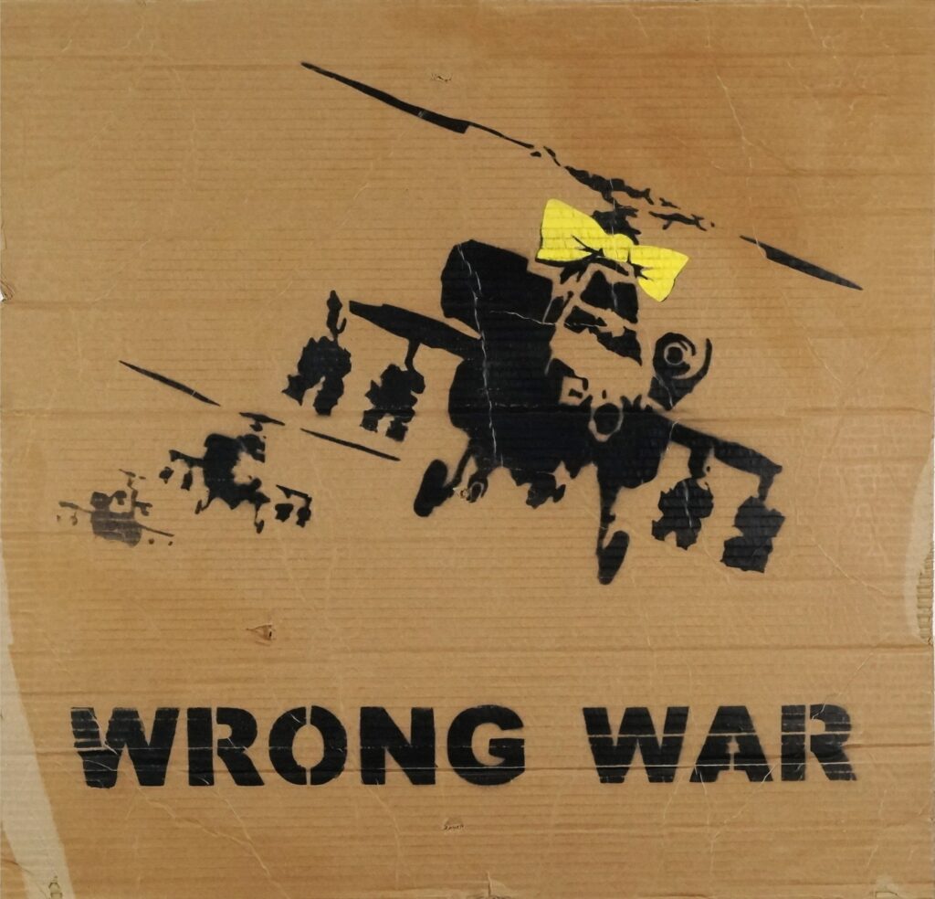 Early Banksy anti Iraq War placards Bomb Hugger and Yellow Chopper have sold for £1,800 each, rare relics from the 2003 London protest march.