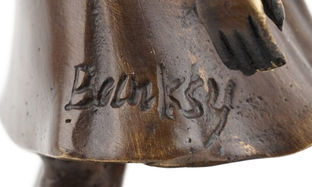 Early Banksy anti Iraq War placards Bomb Hugger and Yellow Chopper have sold for £1,800 each, rare relics from the 2003 London protest march.