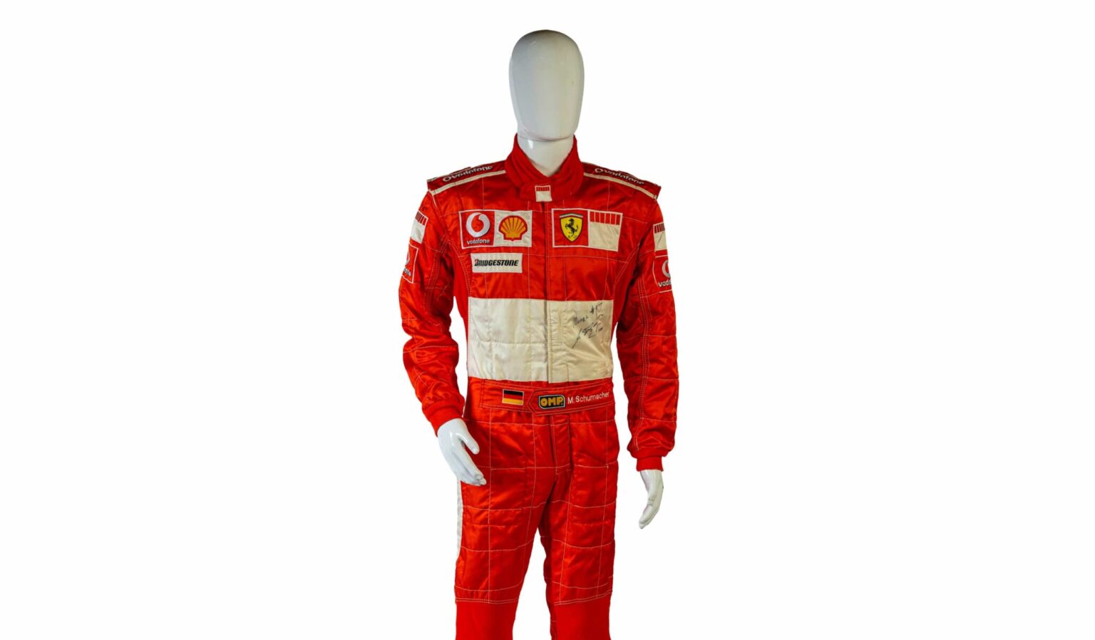 A signed Ferrari racing suit worn by Michael Schumacher at his 2006 Italian Grand Prix win has sold for nearly £100,000, smashing estimates at auction.