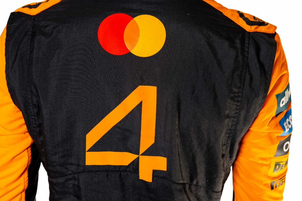 A signed Ferrari racing suit worn by Michael Schumacher at his 2006 Italian Grand Prix win has sold for nearly £100,000, smashing estimates at auction.