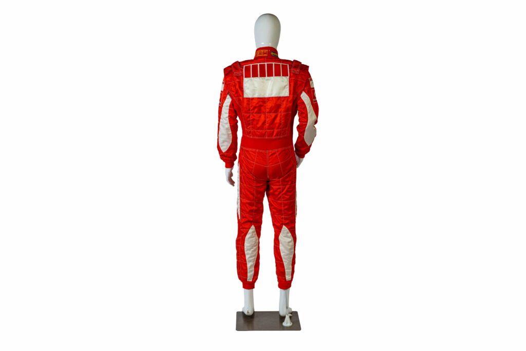 A signed Ferrari racing suit worn by Michael Schumacher at his 2006 Italian Grand Prix win has sold for nearly £100,000, smashing estimates at auction.