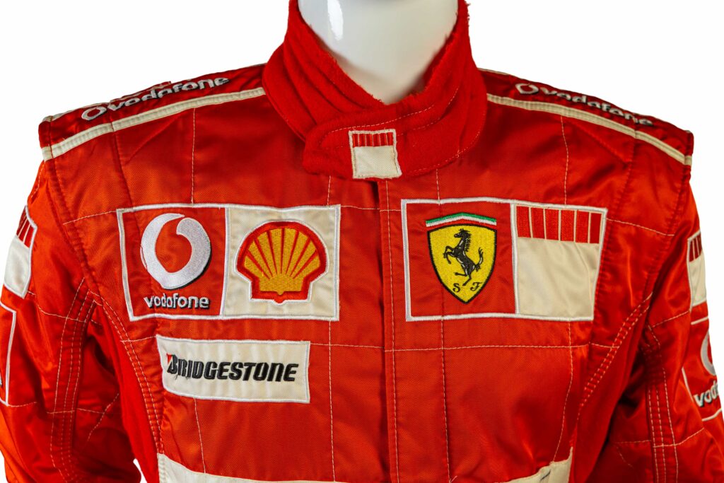 A signed Ferrari racing suit worn by Michael Schumacher at his 2006 Italian Grand Prix win has sold for nearly £100,000, smashing estimates at auction.