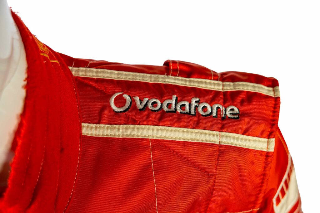 A signed Ferrari racing suit worn by Michael Schumacher at his 2006 Italian Grand Prix win has sold for nearly £100,000, smashing estimates at auction.