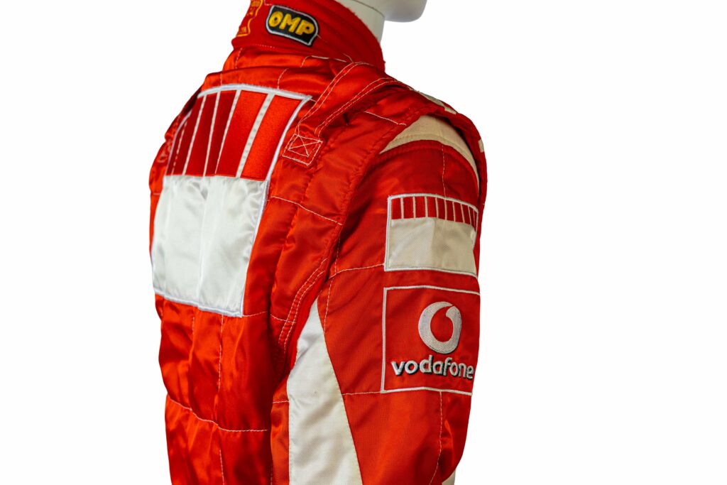 A signed Ferrari racing suit worn by Michael Schumacher at his 2006 Italian Grand Prix win has sold for nearly £100,000, smashing estimates at auction.