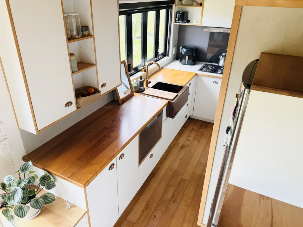 Woman saves £70,000 on bills living in 194 sq ft tiny home for 9 years in New Zealand. Features composting toilet and million-dollar view. Says she made right choice.
