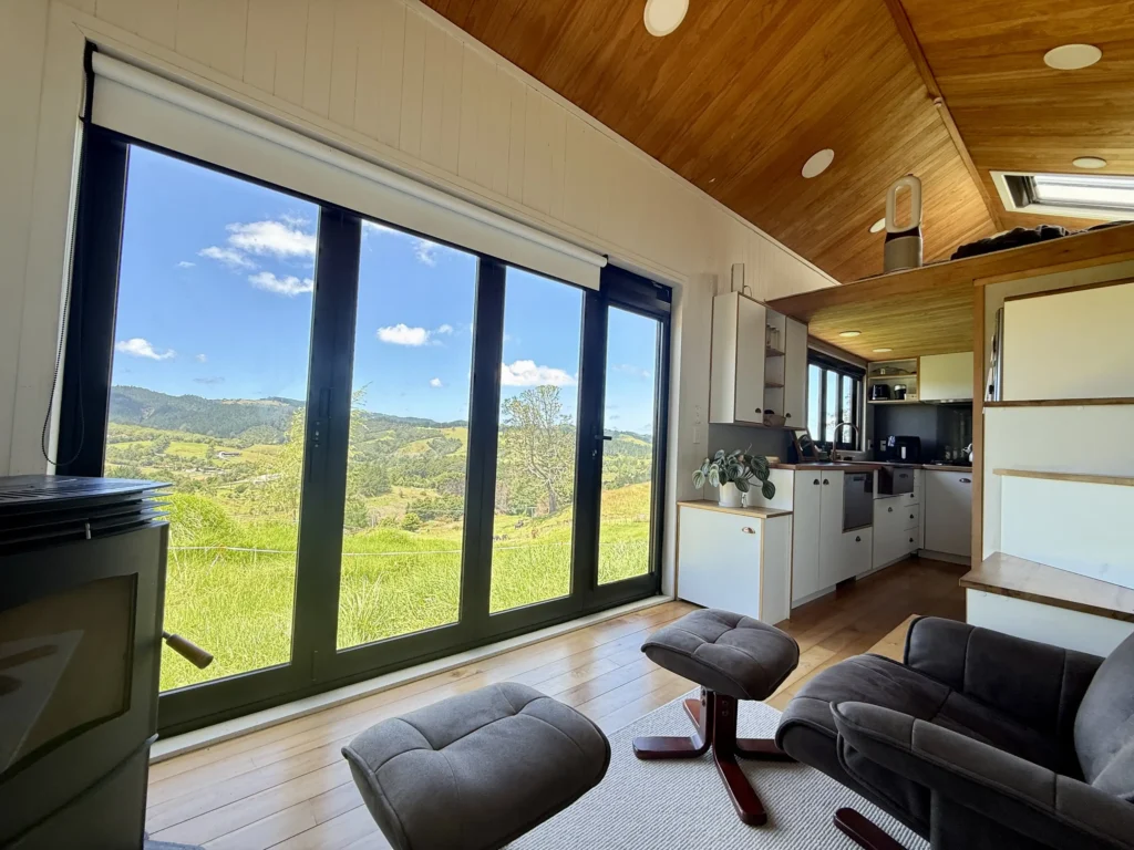 Woman saves £70,000 on bills living in 194 sq ft tiny home for 9 years in New Zealand. Features composting toilet and million-dollar view. Says she made right choice.