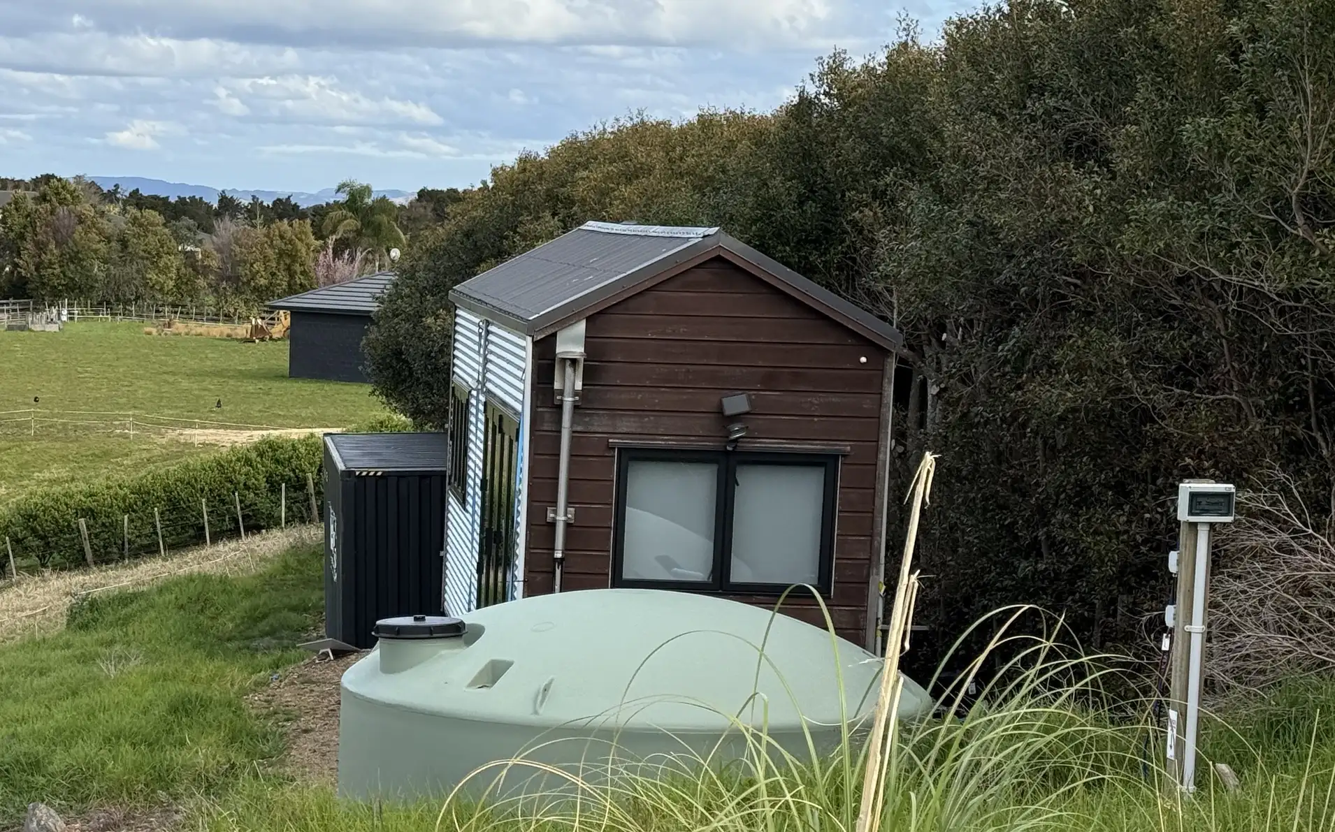 Woman saves £70,000 on bills living in 194 sq ft tiny home for 9 years in New Zealand. Features composting toilet and million-dollar view. Says she made right choice.