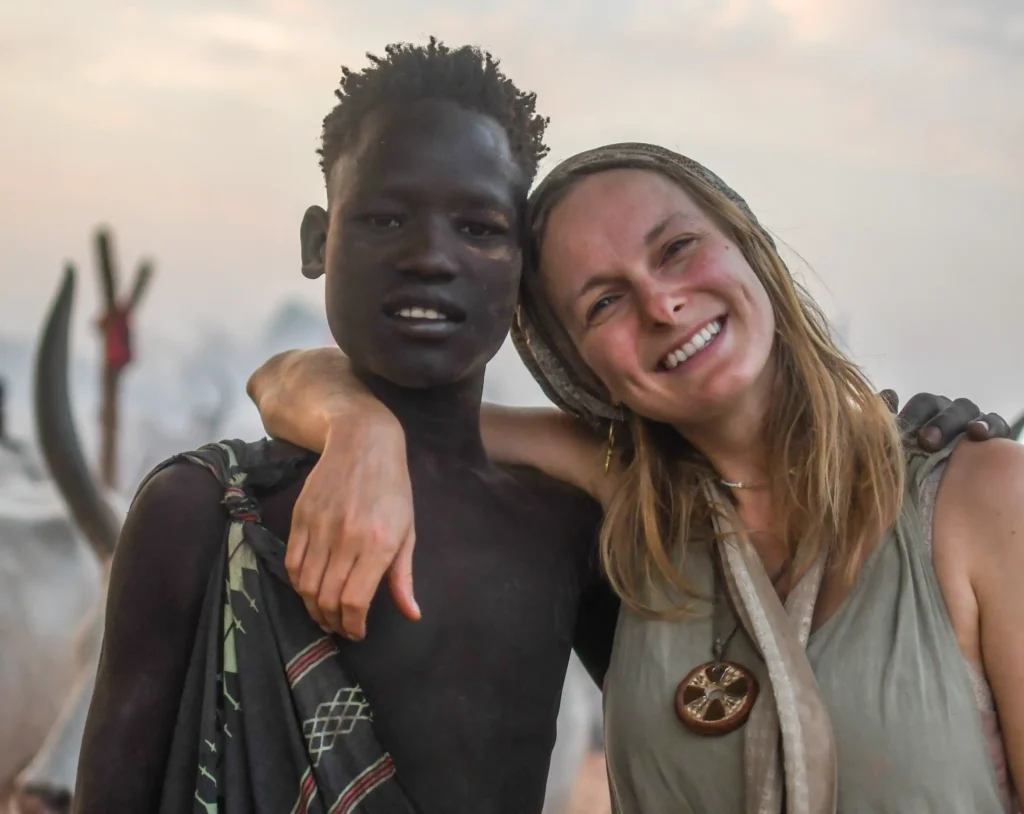 A travel influencer shocked fans after washing her hair in cow urine as part of the Mundari tribe spa experience in South Sudan - squatting under a cow as part of the ritual.