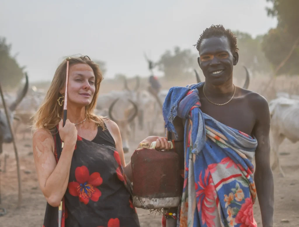 A travel influencer shocked fans after washing her hair in cow urine as part of the Mundari tribe spa experience in South Sudan - squatting under a cow as part of the ritual.