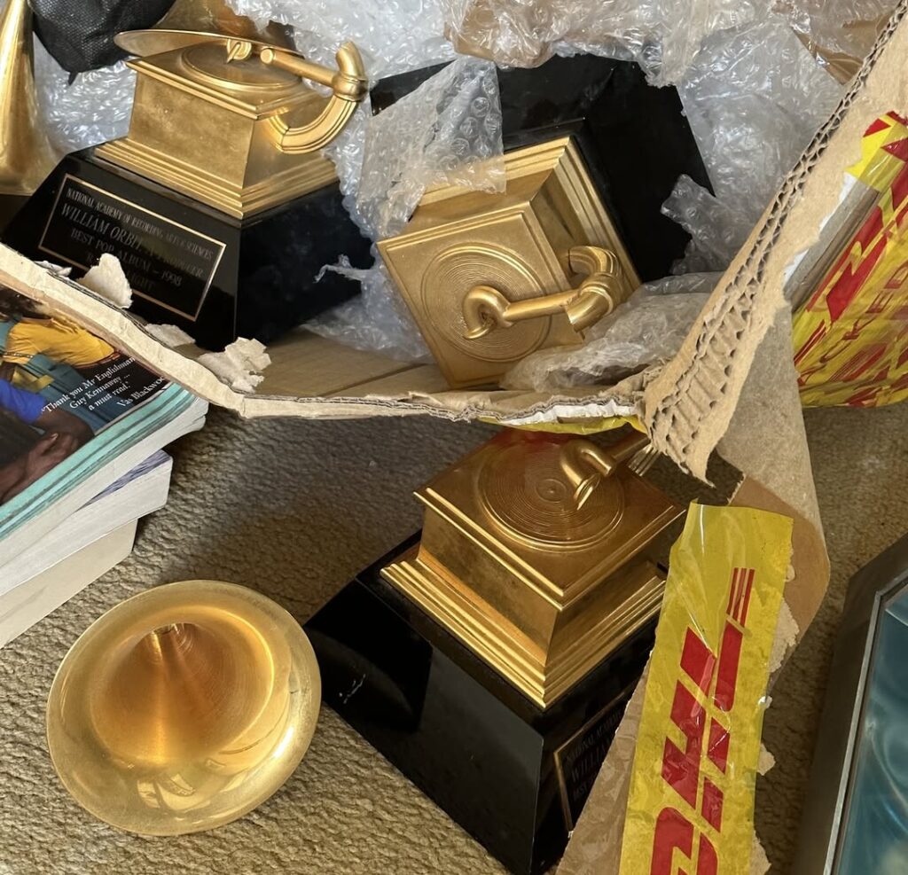 Music producer William Orbit says his three Grammy Awards trophies won for work with Madonna arrived smashed after a damaged DHL delivery from Venice to London.