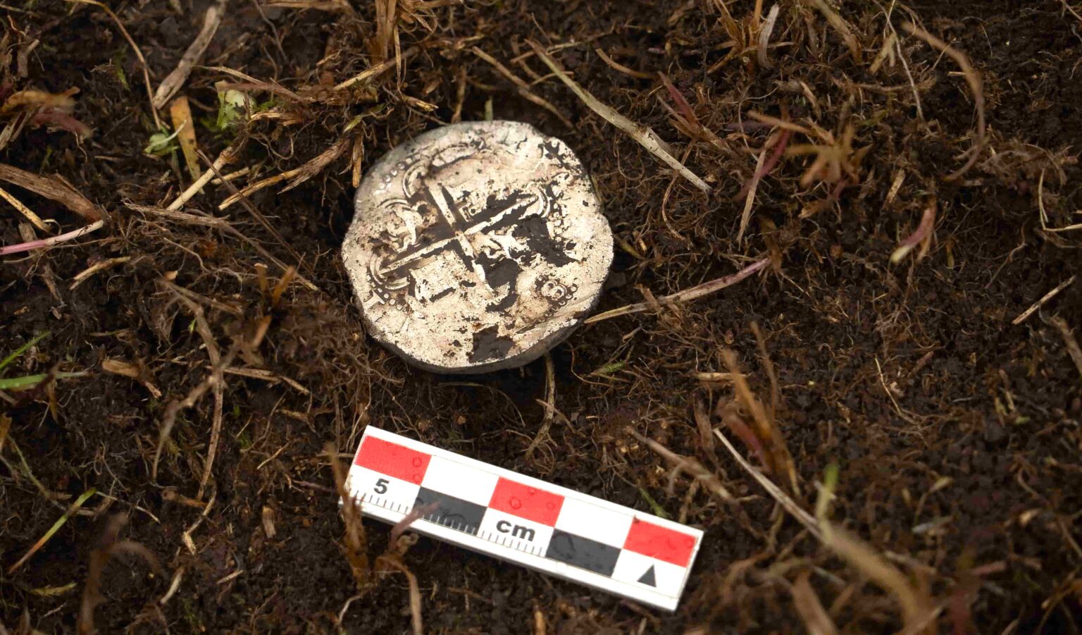 A 400-year-old silver coin unearthed near the Strait of Magellan has pinpointed the exact location of a doomed Spanish colony where most of 350 settlers perished within years.