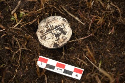 A 400-year-old silver coin unearthed near the Strait of Magellan has pinpointed the exact location of a doomed Spanish colony where most of 350 settlers perished within years.